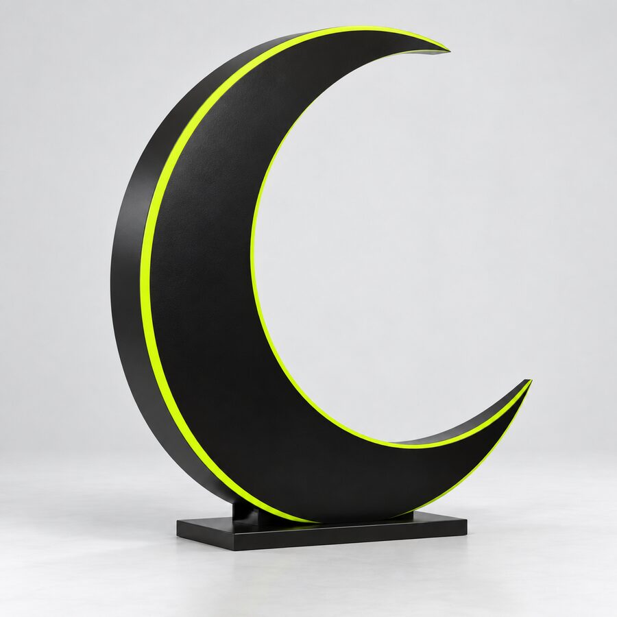 Black sculptural crescent moon prop with a lime rim and stable base